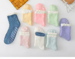 Detail shot of cozy coral fleece fuzzy socks with anti-slip dots, soft winter home wear.