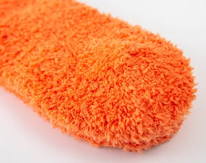 Gedetailleerde close-up van zachte koraalvleece pluche warme winterslaapsok in helder oranje.
