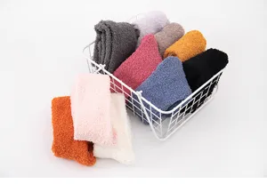 Close-up of cozy colorful fuzzy coral fleece socks neatly arranged in a white wire storage basket.
