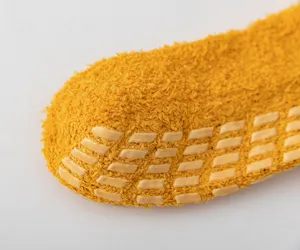 Close-up of winter thick coral fleece anti-slip socks sole detail showing textured grips.