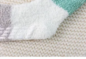Detailed close-up of winter thick coral fleece color-block socks with anti-slip silicone.
