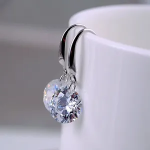 Close-up detail shot of sparkling cubic zirconia dangle earrings featuring silver hooks.