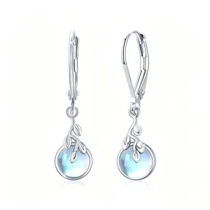 Primer plano detallado de pendientes de plata con piedra de luna y delicados detalles de hojas finas.