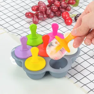 Gros plan du moule à glace en silicone à 7 trous avec poignées colorées et démoulage.