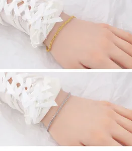 Close up detail shot of the delicate shimmering minimalist chain bracelet showing fine texture.