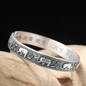 Vue détaillée du jonc argenté vintage à motif d'éléphant avec inscription intérieure.