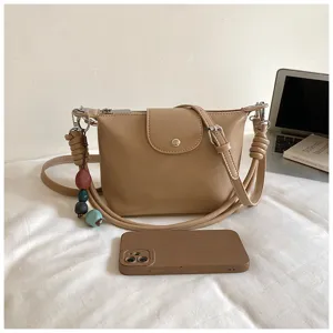 Retro PU leather cross-body shoulder bag for women with stylish strap and chic decorative charm.