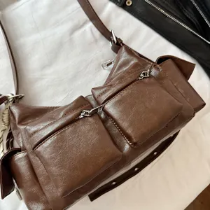 Brown multi-pocket leather shoulder bag, stylish commuter crossbody bag with zipper details.