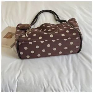 Brown suede polka dot tote bag detail view showing soft texture and dark brown handles.