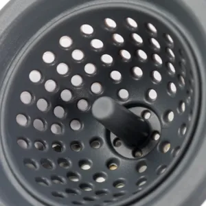 Gros plan détaillé de la passoire d'évier en silicone gris foncé avec trous et poignée.