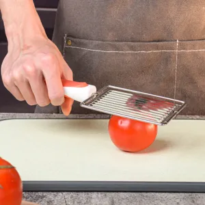 Stainless steel tomato slicer and fruit cutter with non-slip handle for kitchen use.