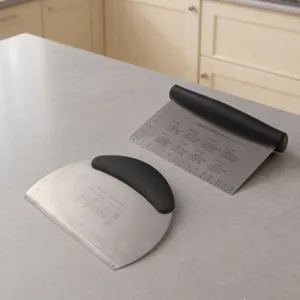 Stainless steel dough scraper detail view, clear measurement scale and baking conversion table.
