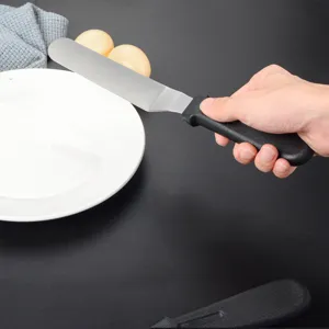 Dettaglio della spatola per dolci in acciaio inossidabile con impugnatura per cottura.