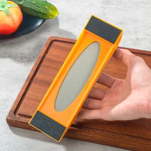 Détail d'aiguiseur de couteau double face avec pierre, cadre orange et extrémités antidérapantes.
