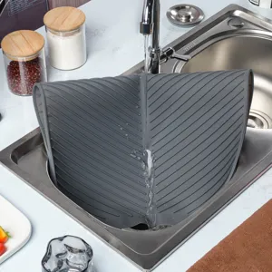 Tapis d'égouttage en silicone gris foncé avec rainures pour protéger le plan de travail.