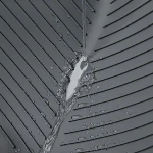 Détail de tapis d'égouttage en silicone avec surface rainurée et eau qui s'écoule.