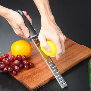 Stainless steel lemon zester and cheese grater detail view showing kitchen food prep usage.