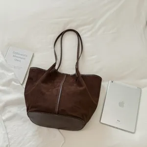 Λεπτομέρεια vintage τσάντας tote από σκούρο καφέ σουέτ, μινιμαλιστική γυναικεία τσάντα.