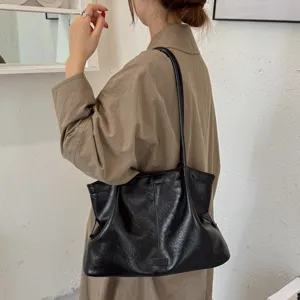 Black large capacity shoulder tote bag detail shot, vintage leather commuter daily use style.