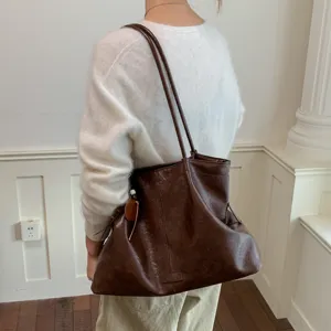 Retro dark brown PU leather tote bag detail shot, large capacity shoulder underarm bag style.