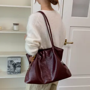 Detailed view of a retro women's large capacity shoulder tote bag in stylish burgundy leather.