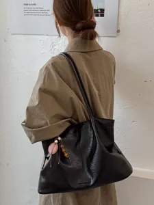 Classic black leather tote bag for women, large capacity stylish shoulder bag for daily commute.