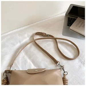 Detail view of the elegant khaki crossbody bag featuring fine strap and flap design.