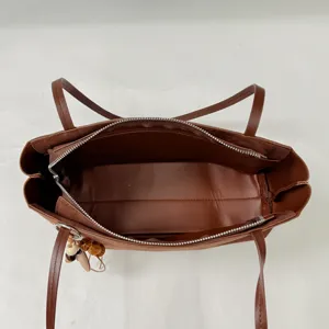Brown leather shoulder tote bag interior detail view, large capacity commuter underarm bag.
