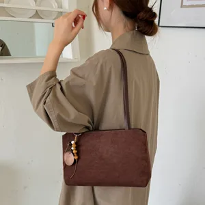 Detailed view of women's vintage brown suede shoulder bag, perfect for autumn commuting.