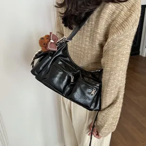 Close up view of the black multi-pocket PU leather shoulder bag details and cute bear charm.
