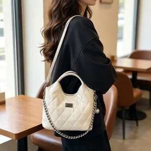 Gedetailleerd shot van witte gewatteerde schoudertas met ketting in café, elegante stijl.