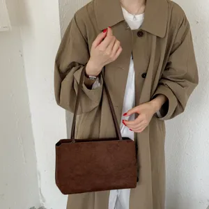 Stylish brown suede underarm shoulder bag, elegant vintage daily commute accessory detail view.