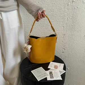 Sac seau jaune élégant avec poignée tressée et pendentif ours pour femmes automne chic