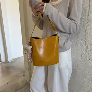 Sac seau jaune rétro avec poignée tressée et charm d'ours mignon, sac bandoulière tendance.