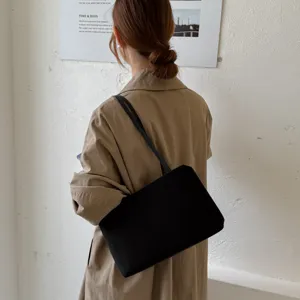 Classic black underarm shoulder bag detail shot, minimalist fashion design for daily commute.