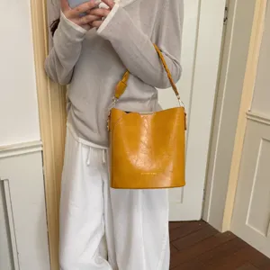 Sac seau jaune vintage pour femme, sac à bandoulière en cuir PU avec poignée tressée élégante.