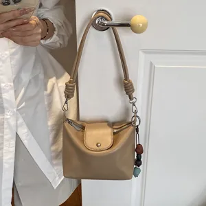Detail view of a chic beige shoulder bag with knot strap, perfect for casual daily commuting.