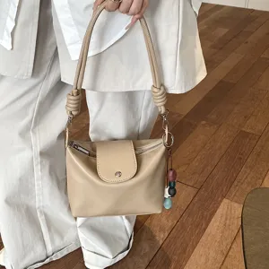 Detailed shot of beige women shoulder bag, vintage casual crossbody PU leather handbag with knots.