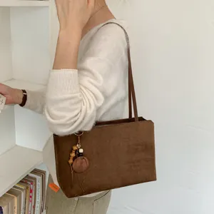 Brown suede shoulder bag detail showing retro design, autumn winter fashion commuting tote.
