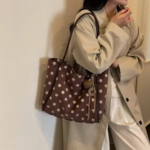 Stylish brown polka dot tote bag detail, featuring casual design and cute heart charm.
