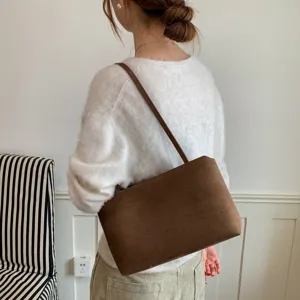 Brown suede underarm shoulder bag detail, stylish women's commuting tote, retro fashion look.