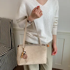 Retro suede shoulder underarm bag with wooden bead pendant detail, chic commuter design.