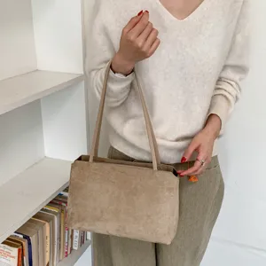 Retro suede shoulder bag for women, elegant commuter underarm tote with zipper closure and slim straps.