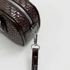 Dunkelbraune geflochtene Leder Umhängetasche Detailansicht, stilvolles und elegantes Accessoire.