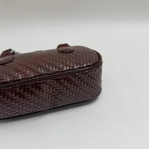 Detailansicht der dunkelbraunen gewebten Ledertasche mit exquisiter Textur und Design.