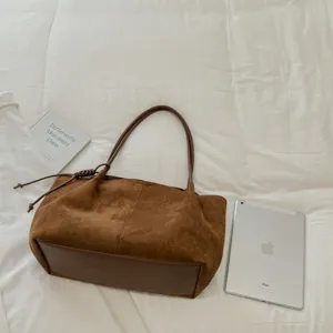Brown suede shoulder tote bag detail view, casual commuting handbag with stylish leather base.