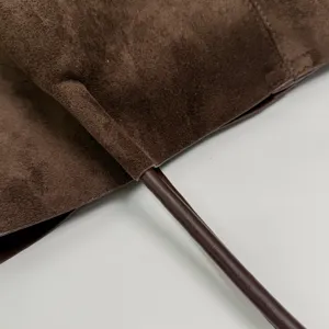 Brown suede tote bag detail view, premium leather handle, elegant commuting shoulder bag.