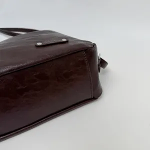 Dark brown women shoulder tote bag detail shot, premium leather texture minimalist design.