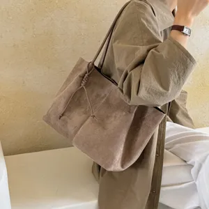Brown suede tote bag detail, featuring a stylish knot strap and large capacity design.