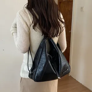 Black soft leather multi-use backpack and tote bag with slouchy design and zip details.